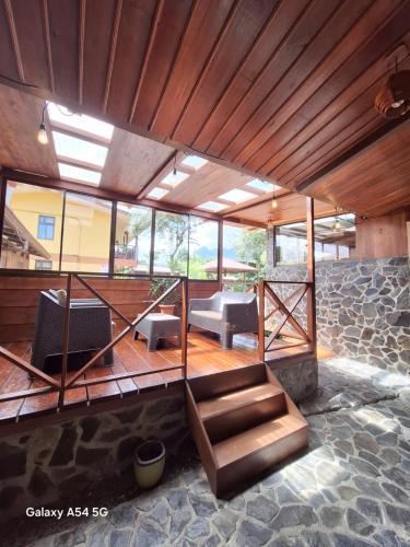 a room with a staircase and some chairs and windows at Hotel Iris Arenal in Fortuna