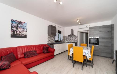 a living room with a red couch and a table at 2 Bedroom Lovely Apartment In Rtina in Rtina