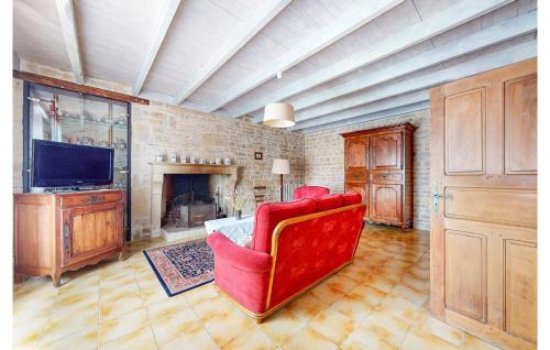 a living room with a red chair and a television at 3 Bedroom Cozy Home In Ligné in Ligné