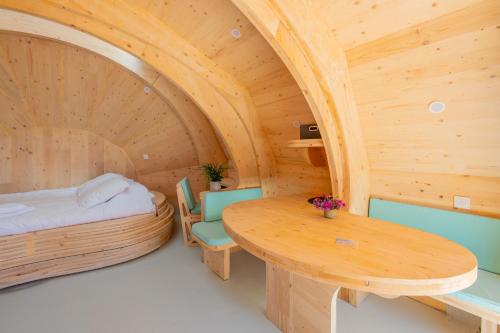 a wooden room with a bed and a table at Les chaumières de Brameix in Neuvic