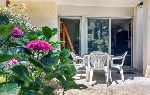 - deux chaises et une table sur une terrasse couverte fleurie dans l'établissement 1 Bedroom Amazing Apartment In Carnac, à Carnac