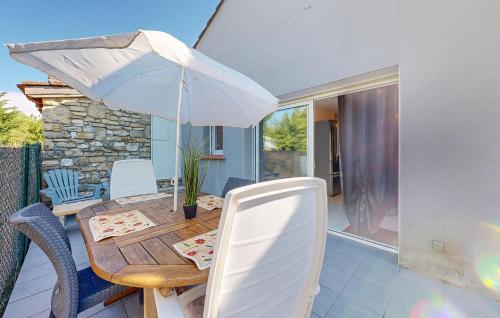 - une table en bois avec un parasol sur la terrasse dans l'établissement 2 Bedroom Gorgeous Home In Mercuès, à Mercuès