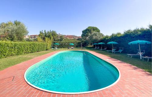 a large swimming pool on a brick patio with umbrellas at Lovely Apartment In Tuoro Sul Trasimeno With Wifi in Tuoro sul Trasimeno
