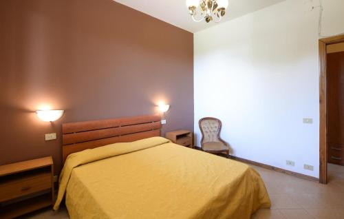 a bedroom with a yellow bed and a chair at Lovely Apartment In Tuoro Sul Trasimeno With Wifi in Tuoro sul Trasimeno