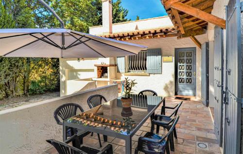 un patio avec une table, des chaises et un parasol dans l'établissement Cozy Home In Fournès With Wifi, à Fournès