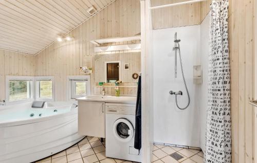 a bathroom with a tub and a washing machine at Stunning Home In Humble With Sauna in Humble
