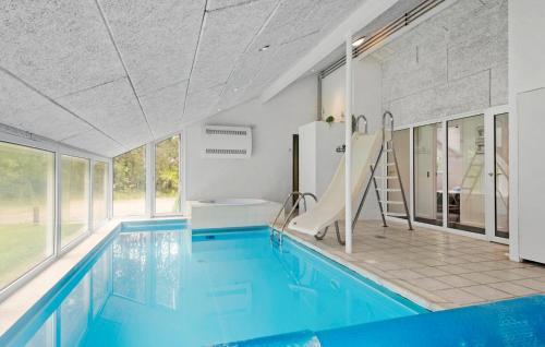 an indoor swimming pool with a slide in a house at Stunning Home In Nørre Nebel With Sauna in Nørre Nebel