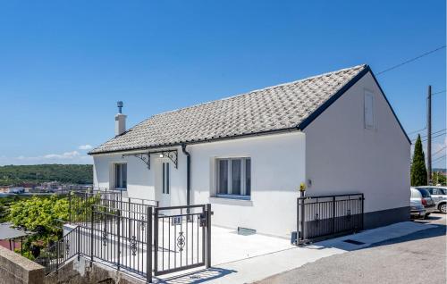 a white house with a gate in a parking lot at Amazing Home In Kukuljanovo With Wifi in Kukuljanovo