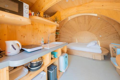 a kitchen with a bed and a sink in a room at Les chaumières de Brameix in Neuvic