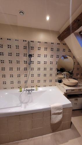 a bathroom with a bath tub and a sink at Moulin de Giboudet Chambres d'hôtes in Bazainville