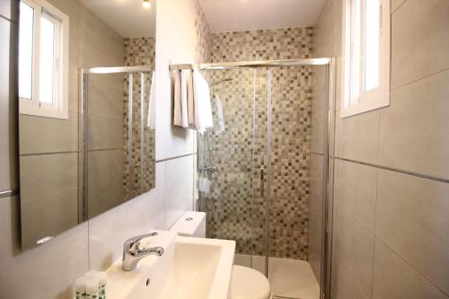 a bathroom with a shower and a toilet and a sink at Las Atarazanas - Design Hostal in Seville