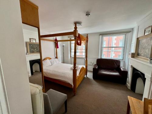 Un dormitorio con una cama con dosel y una chimenea. en Stay in Bloomsbury, en Londres