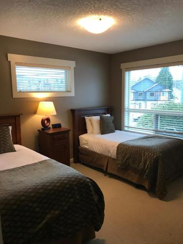 a hotel room with two beds and a window at Sheringham Townhouse - Sooke in Sooke