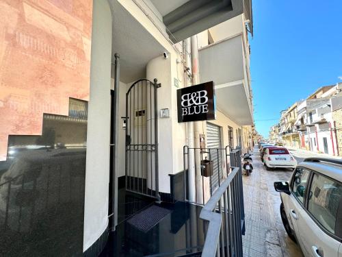 a building with a blue sign on the side of a street at B&B Blue in Terrasini
