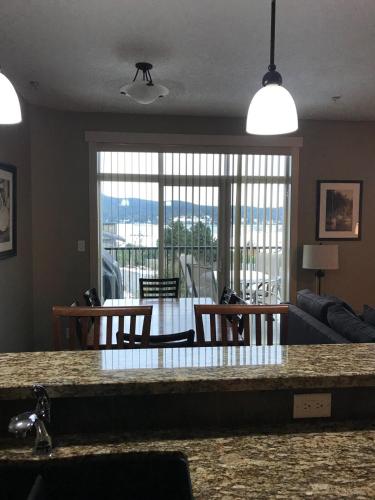 a kitchen and living room with a table and chairs at Sheringham Townhouse - Sooke in Sooke