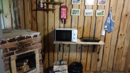 a microwave sitting on a shelf next to a fireplace at Tiny Cozy House in Pärispea