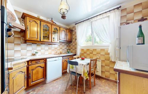 une cuisine avec des armoires en bois et une table avec des chaises dans l'établissement 3 Bedroom Lovely Home In Fontenay, à Fontenay