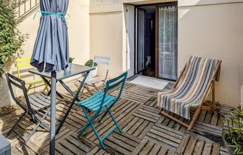 - 2 chaises, une table et un parasol sur la terrasse dans l'établissement 1 Bedroom Nice Apartment In Pornichet, à Pornichet