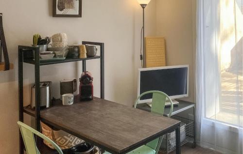 une table avec un ordinateur et un bureau avec des chaises dans l'établissement 1 Bedroom Nice Apartment In Pornichet, à Pornichet