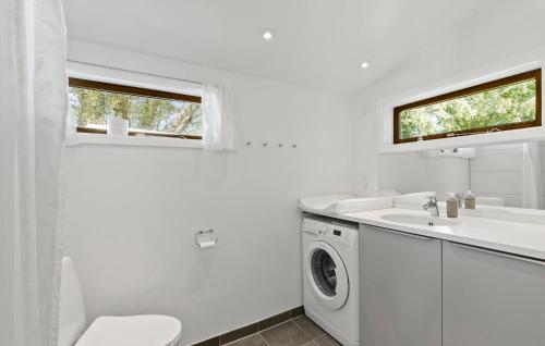 a white bathroom with a sink and a washing machine at 4 Bedroom Stunning Home In Gilleleje in Gilleleje