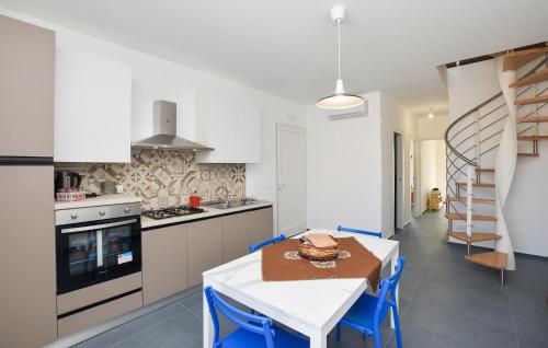 a kitchen with a table and chairs and a staircase at Cozy Apartment In Santa Croce Camerina in Santa Croce Camerina