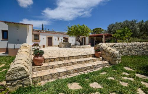 a stone retaining wall and stairs in front of a house at Tenuta Flaccavento in Chiaramonte Gulfi