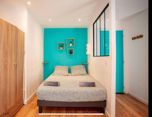 une chambre avec un lit avec un mur bleu dans l'établissement Grand studio proche Gare, Parc Longchamp, à Marseille