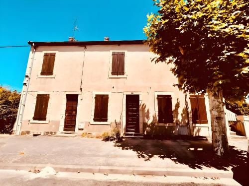 an old white building with a tree in front of it at Le Sweet Terracotta - Home Homy in Montluçon