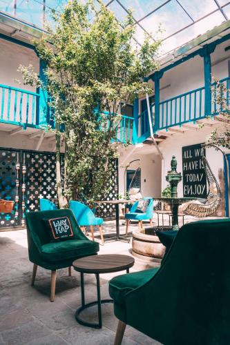 a group of chairs and tables in a patio at Way Kap Hostel Cusco in Cusco