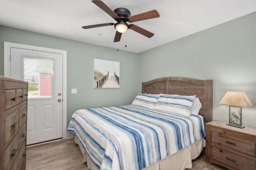 une chambre avec un lit et un ventilateur de plafond dans l'établissement NH387E Currituck Cottage, à Nags Head