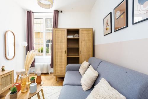 un salon avec un canapé bleu et une table dans l'établissement Studio en Plein Centre de Paris, à Paris