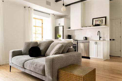 a living room with a couch and a kitchen at Maison Rasco by Luxury In Transit in Montréal