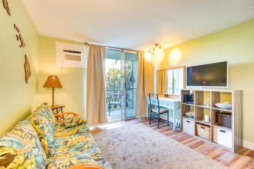a living room with a couch and a table with a television at Downtown Kailua-Kona Escape Steps to Ocean! in Kailua-Kona