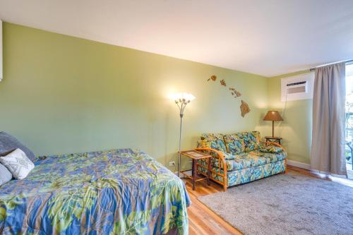 a bedroom with a bed and a couch and a window at Downtown Kailua-Kona Escape Steps to Ocean! in Kailua-Kona
