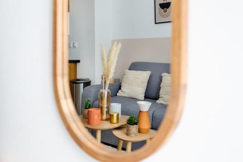 un miroir reflétant un salon avec un canapé bleu dans l'établissement Studio en Plein Centre de Paris, à Paris