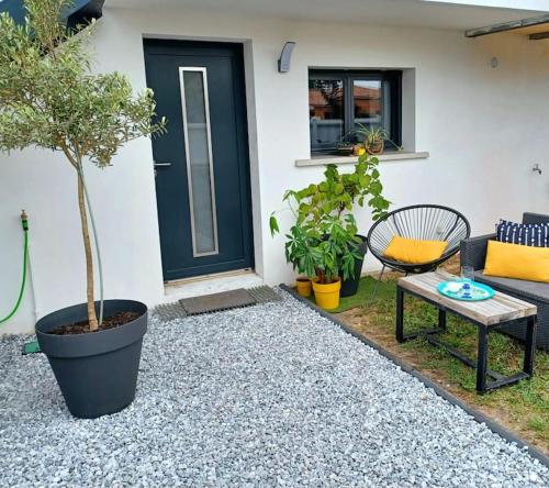 a patio with a couch and a table and trees at Studio entre Bordeaux et océan in Saint-Médard-en-Jalles