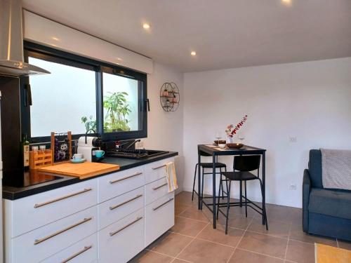 a kitchen with a counter and a table and a window at Studio entre Bordeaux et océan in Saint-Médard-en-Jalles