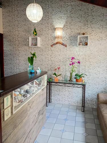 a room with two tables and potted plants on the wall at Hotel Recanto do Sol in Cananéia