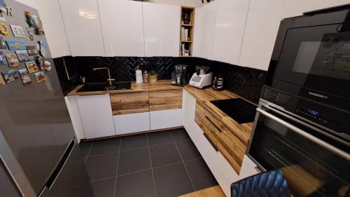 une petite cuisine avec des armoires blanches et un appareil noir dans l'établissement Charmant Appartement Cosy Calme, à Saint-Maurice