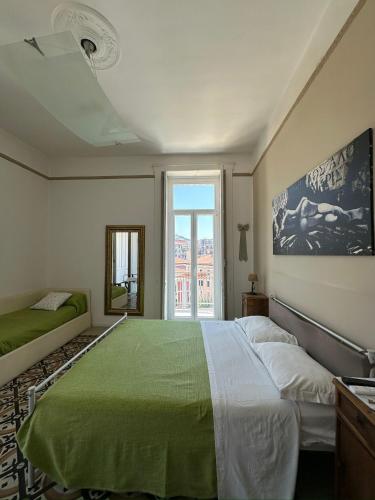 a bedroom with a green bed and a window at L'Una di Notte in Salerno