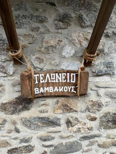 a sign on the side of a stone wall at Τελωνείο Βαμβακούς in Vamvakoú