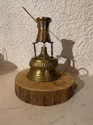 a gold vase sitting on a wooden stump at Τελωνείο Βαμβακούς in Vamvakoú