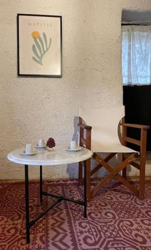 a table and a chair in a room at Τελωνείο Βαμβακούς in Vamvakoú