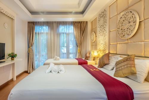 a bedroom with two beds and a television at SHIN Hotel Chiangmai Gate in Chiang Mai