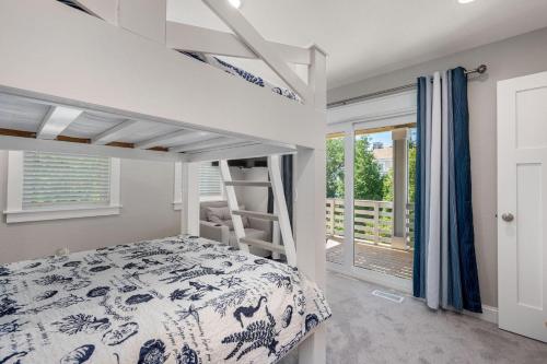 Un dormitorio con una litera y un balcón. en WE17 Benders Beach Bungalow, en Nags Head