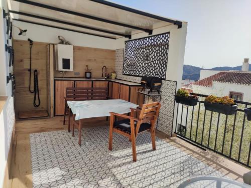 patio ze stołem i kuchnią na balkonie w obiekcie Casa Salomé Frigiliana w mieście Frigiliana