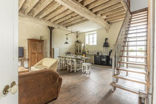 Il comprend un grand salon avec un canapé et une cuisine. dans l'établissement Chez Marguerite et Bienaimé, à Picauville