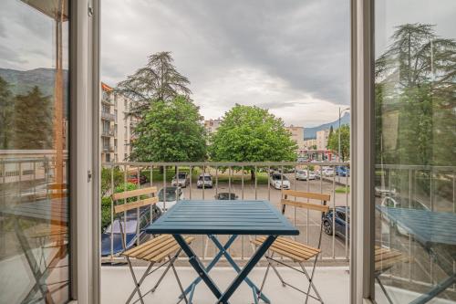 einen Tisch auf einem Balkon mit Straßenblick in der Unterkunft Le Jardin Secret in Seyssinet-Pariset