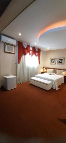 a large bedroom with two beds and a window at Skalla Hotel Nova Odessa in Nova Odessa