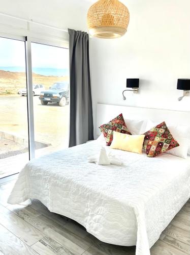 a bedroom with a large white bed with pillows at Casa Gary in Caleta de Caballo